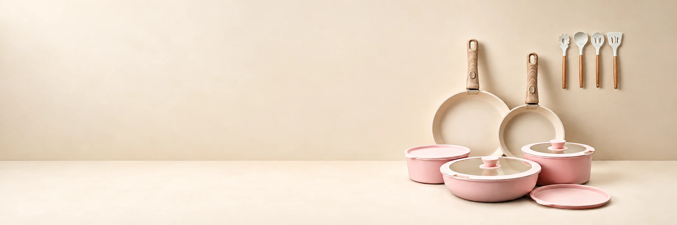 Pink detachable cookware and matching utensils in a continuous warm cream scene