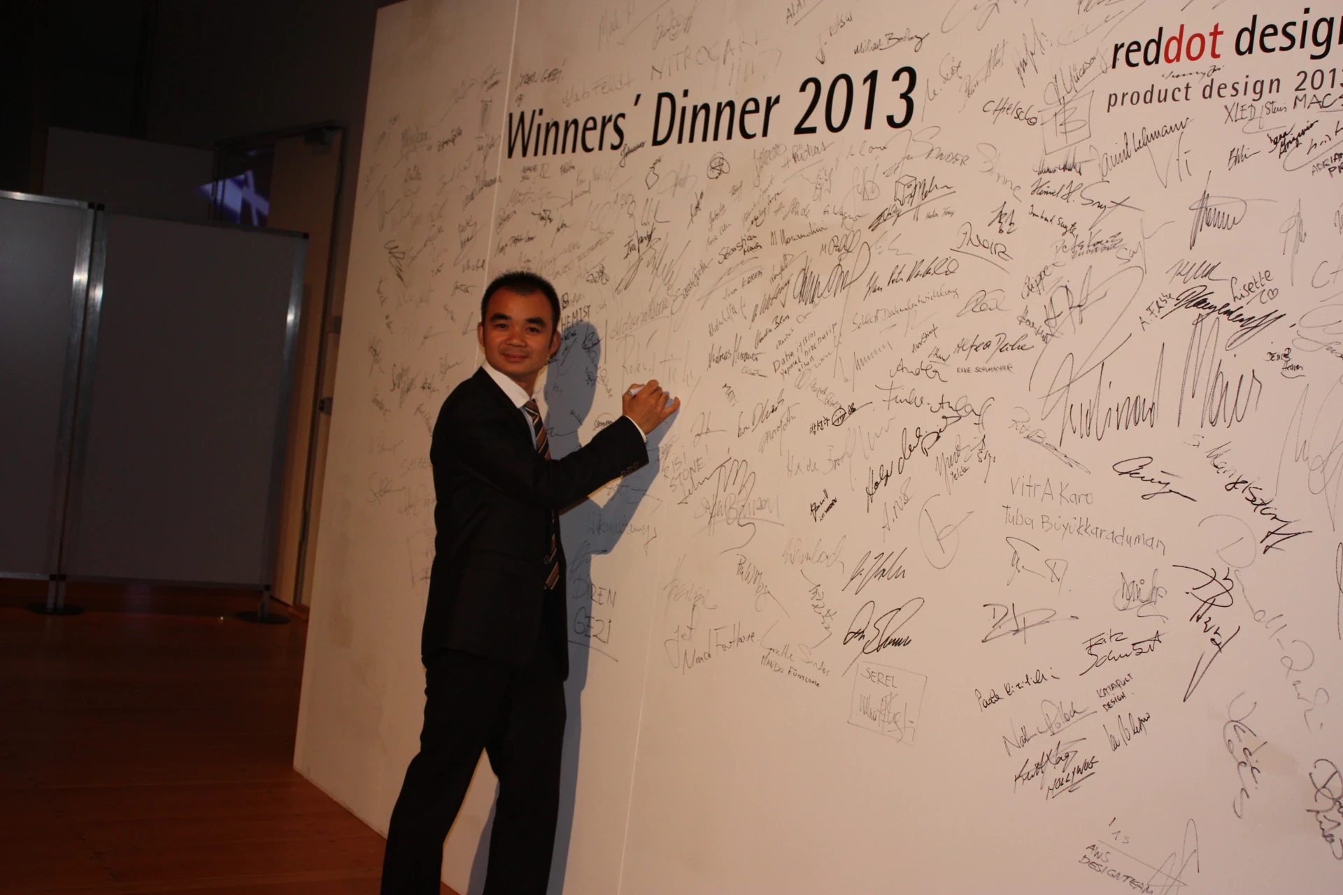 Founder Yuan Yuanfan signing the wall at the Red Dot Winners’ Dinner in 2013